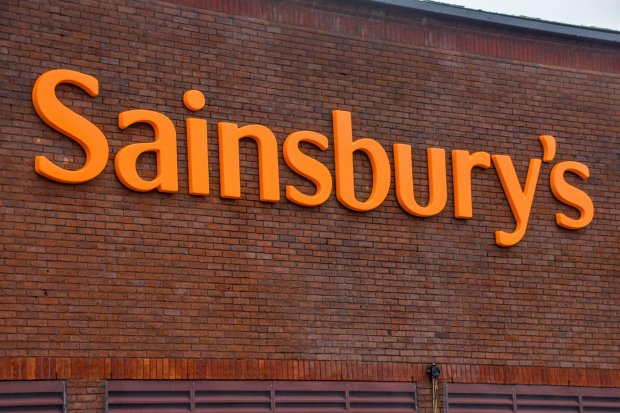 Sainsbury's logo on a brick wall.