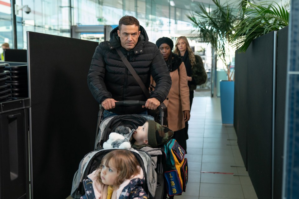 A man pushing a double stroller through an airport terminal, followed by two women.
