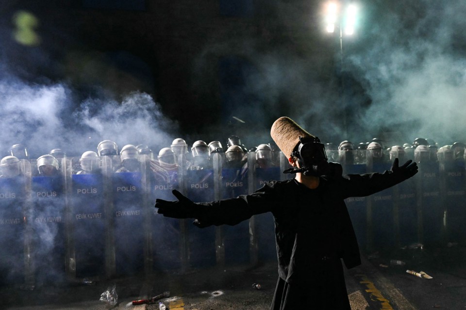 Whirling dervish facing riot police during a rally.