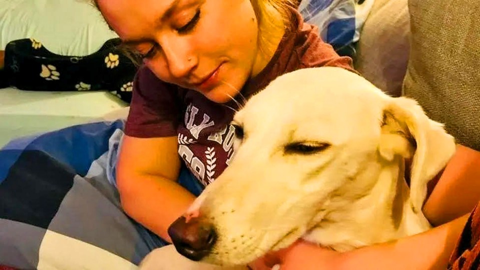 Woman cuddling a rescued dog.
