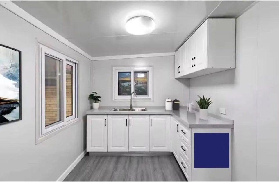 Interior view of a small, modern kitchen in a prefabricated home.