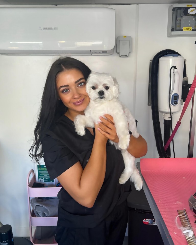 Woman holding a small white dog.