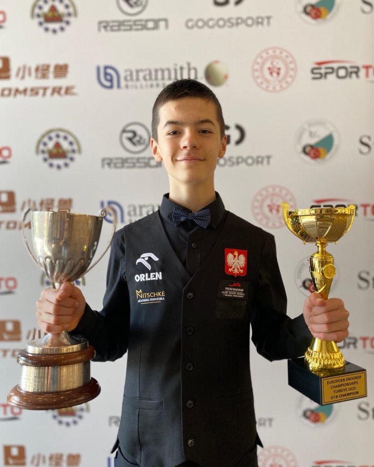 Boy holding two trophies.