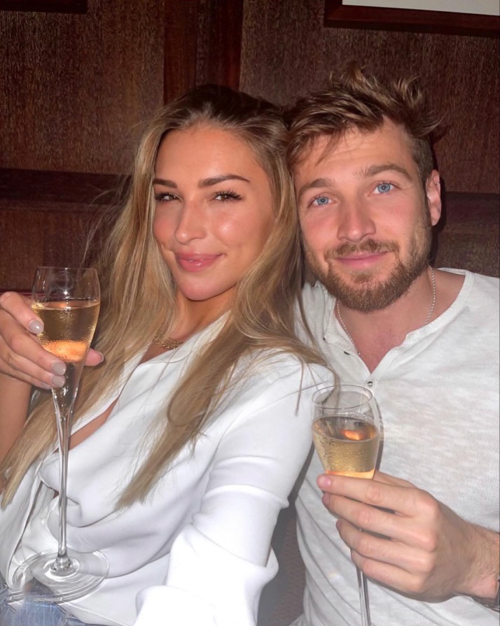Zara McDermott and Sam Thompson holding champagne glasses.