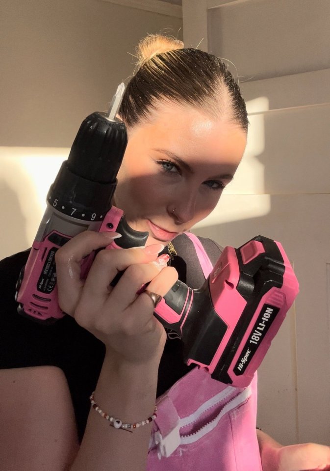 Woman holding a pink cordless drill.