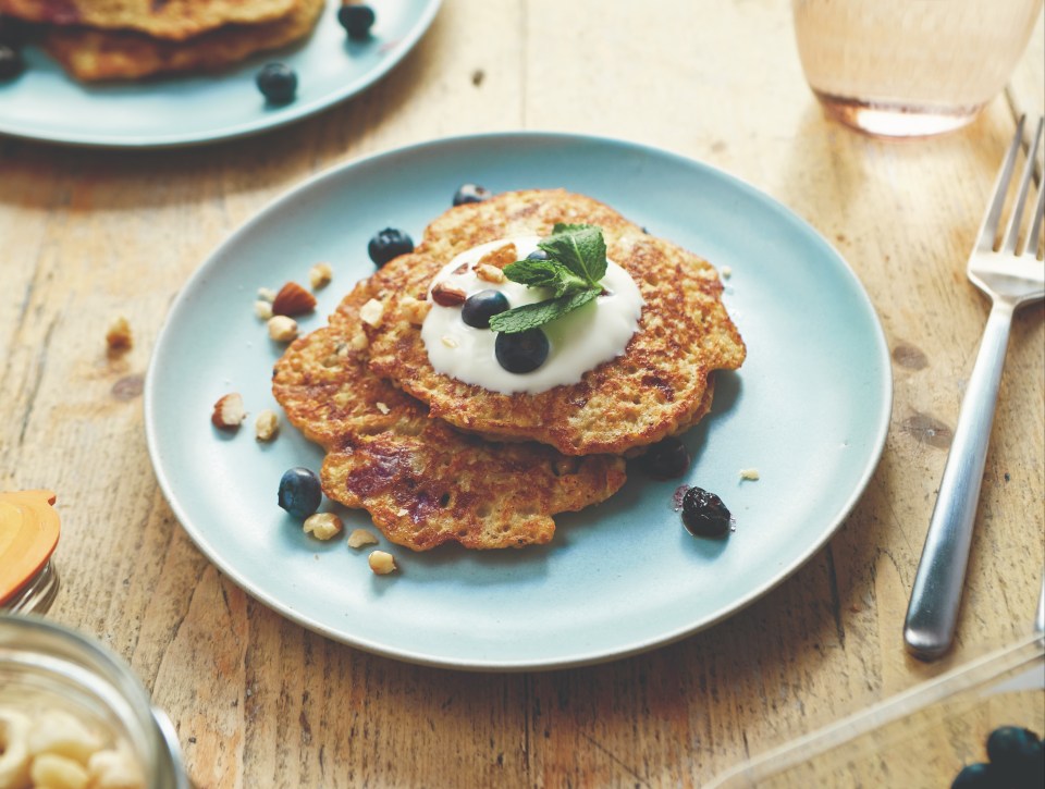 Blueberry pancakes topped with yogurt, nuts, and mint.