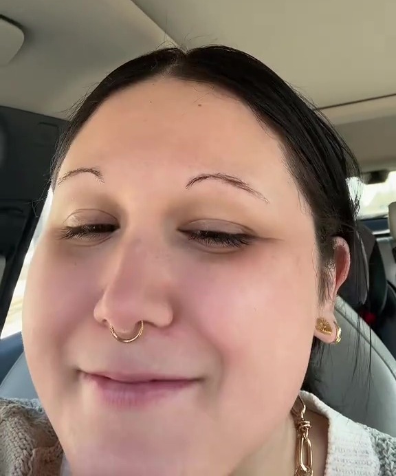 Woman in a car inviting viewers to get their eyebrows laminated with her.