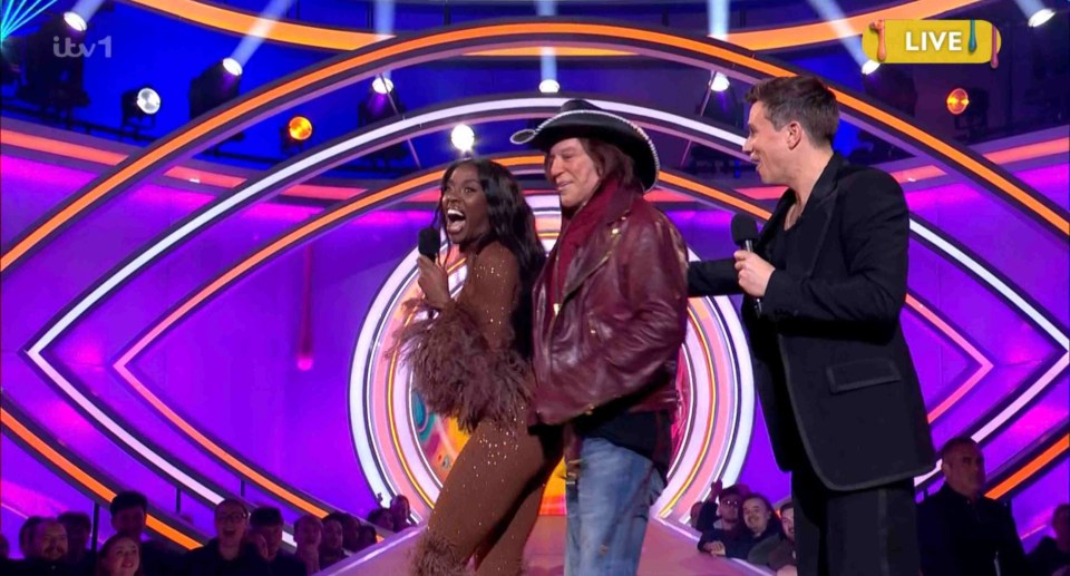 Screenshot of a live TV show featuring three people on stage.