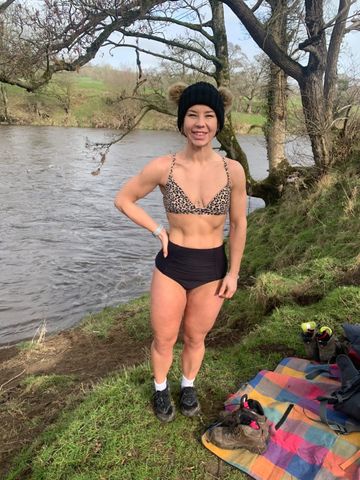 Woman in swimsuit by river.