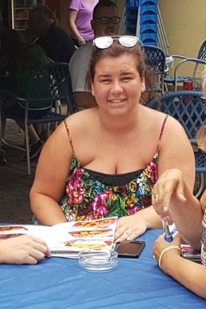 Woman sitting at a table, smiling.