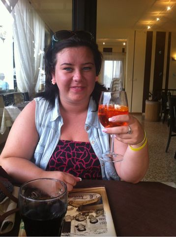 Woman holding a glass of Aperol Spritz.