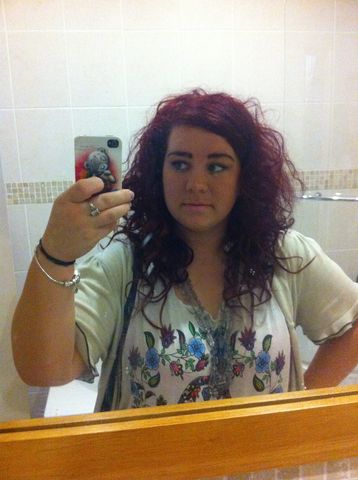 Woman taking a selfie in a bathroom mirror.