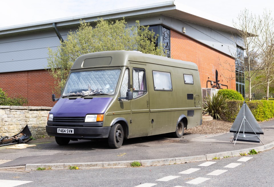A green van parked in a parking lot.