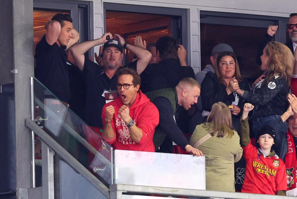 Rob McElhenney and Ryan Reynolds celebrating at a soccer match.