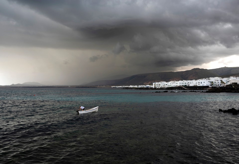 Stormy weather over Punta Mujeres, Lanzarote, with a small boat in the foreground.