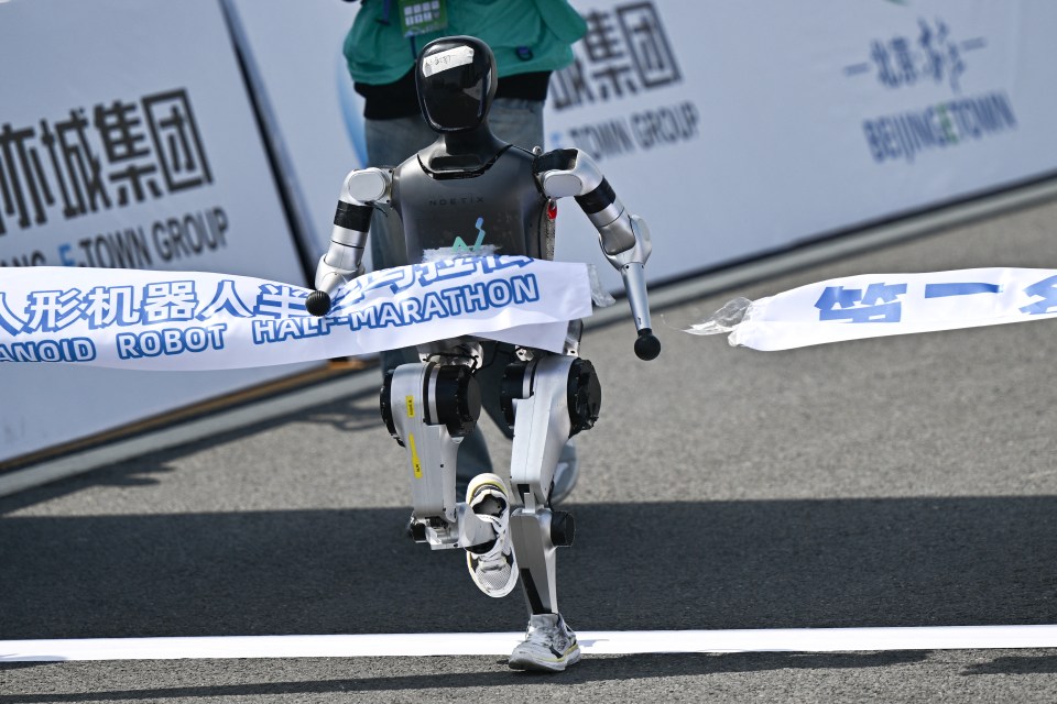 Humanoid robot crossing the finish line of a half-marathon.