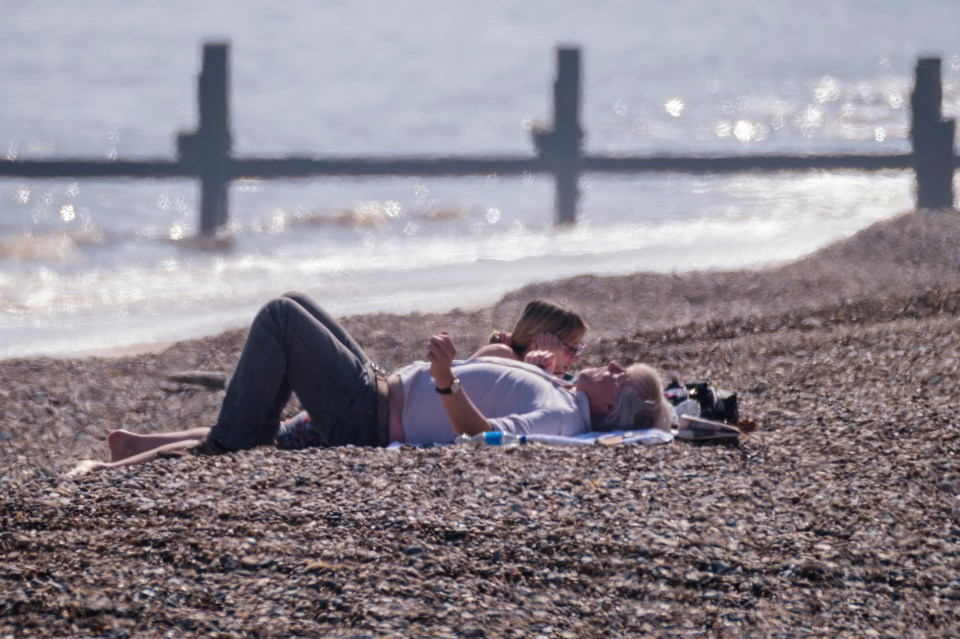 Couple relaxing on a pebble beach.