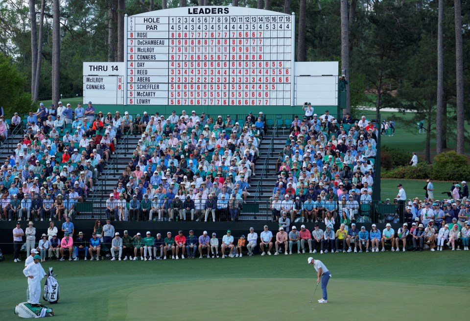 Rory McIlroy putting on the green, with a leaderboard and spectators in the background.