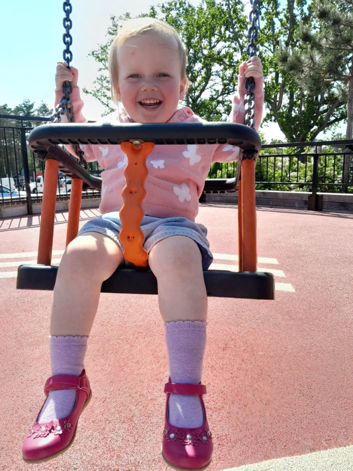 Toddler on a swing.