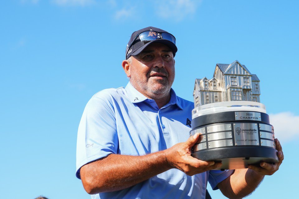 Golfer holding the 2025 James Hardie Pro-Football Hall of Fame Invitational trophy.
