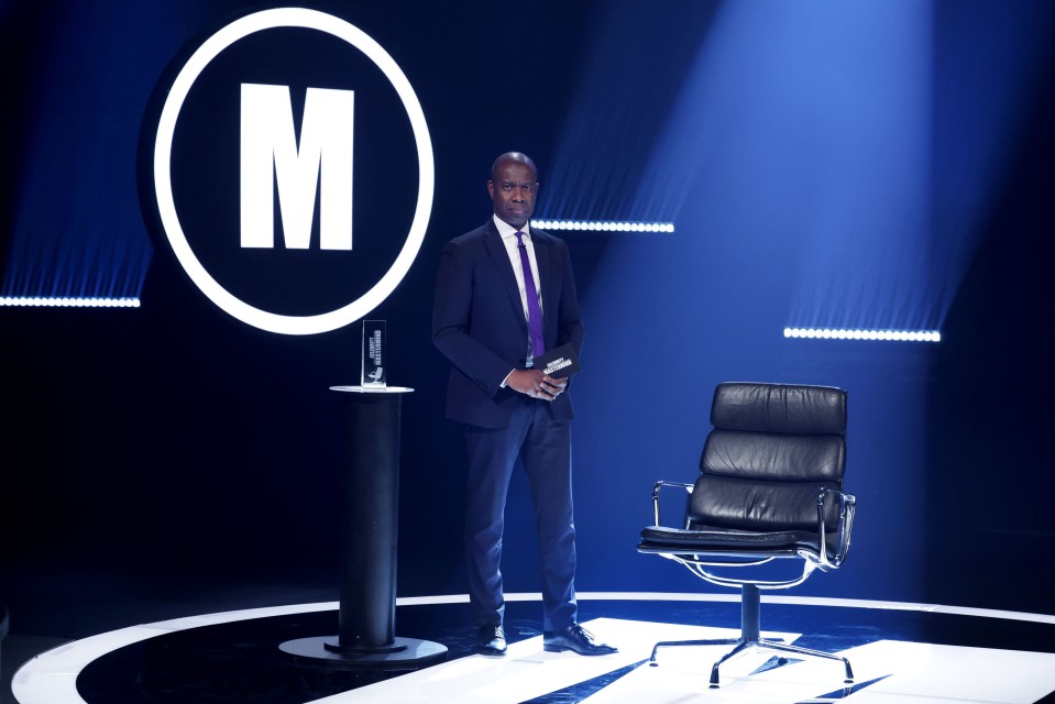 Clive Myrie on the set of Celebrity Mastermind, holding the trophy.