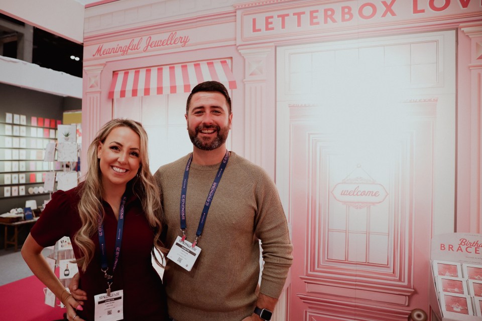 Portrait of a man and woman at a trade show booth.