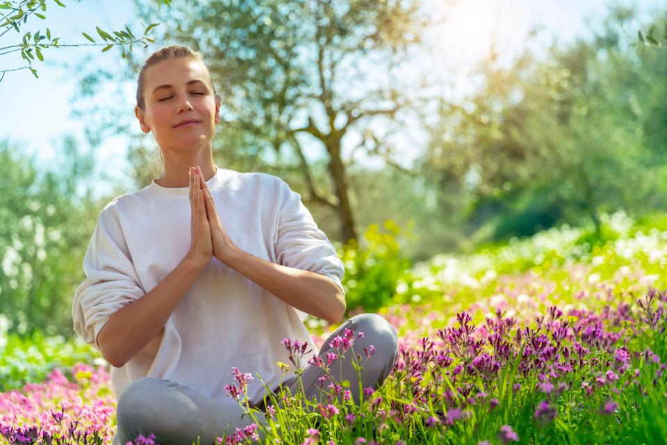 Woman meditating in a garden.