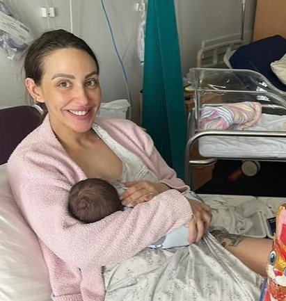 Lizzie Sobinoff breastfeeding her newborn baby in a hospital room.