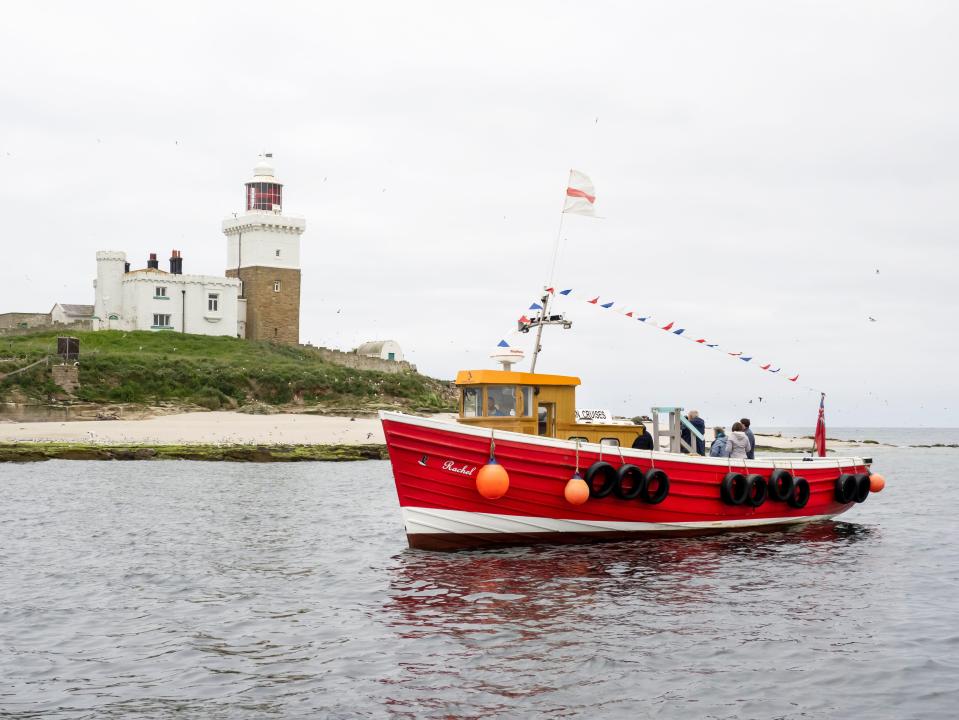 Tourist boat near a lighthouse.