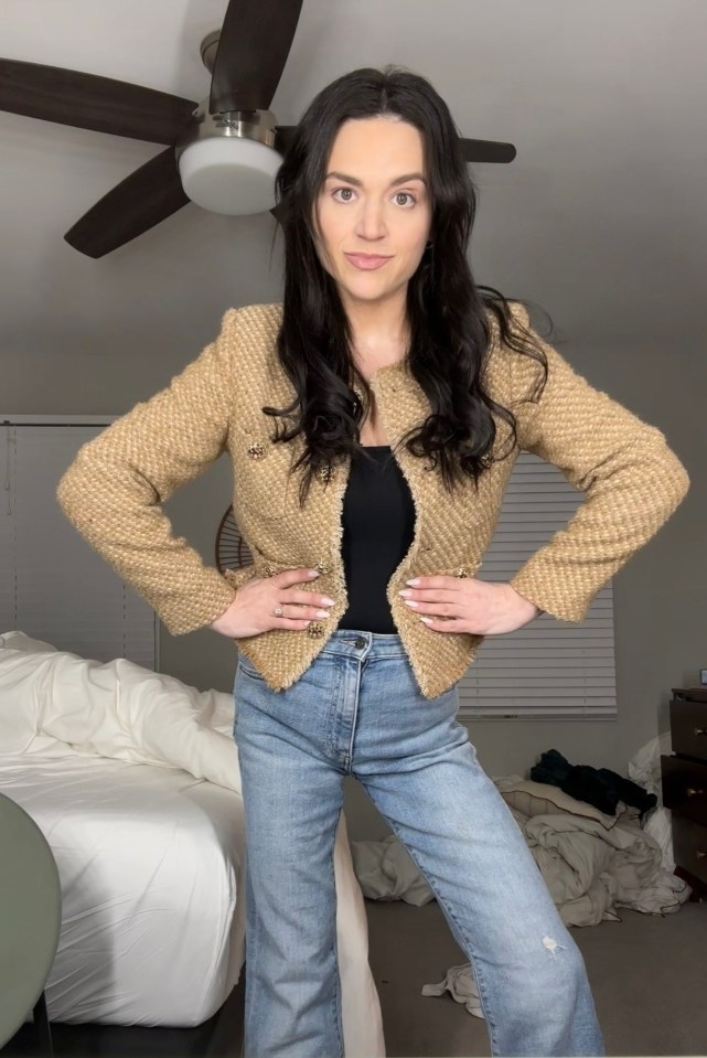 Woman in tan jacket and jeans.