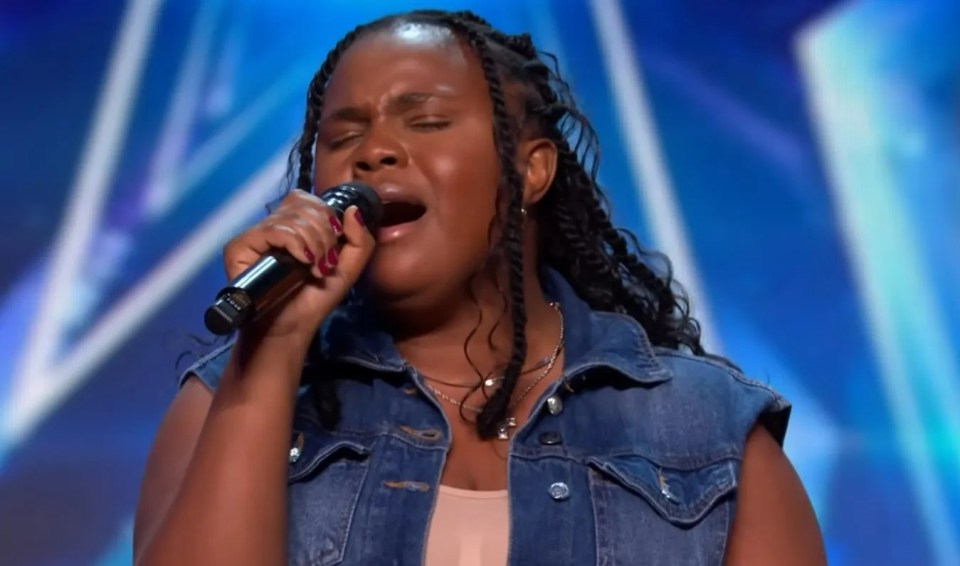 Linda Mudzenda singing into a microphone.