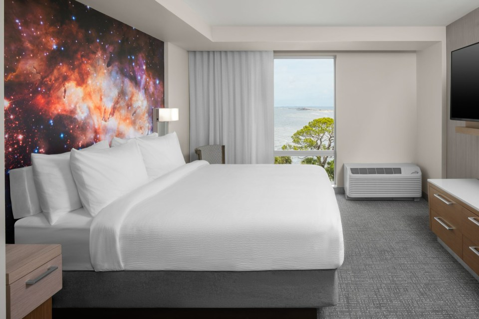 Hotel room with king-size bed and ocean view.