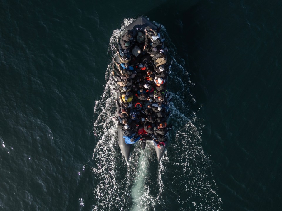 Aerial view of a crowded inflatable boat carrying migrants across the English Channel.