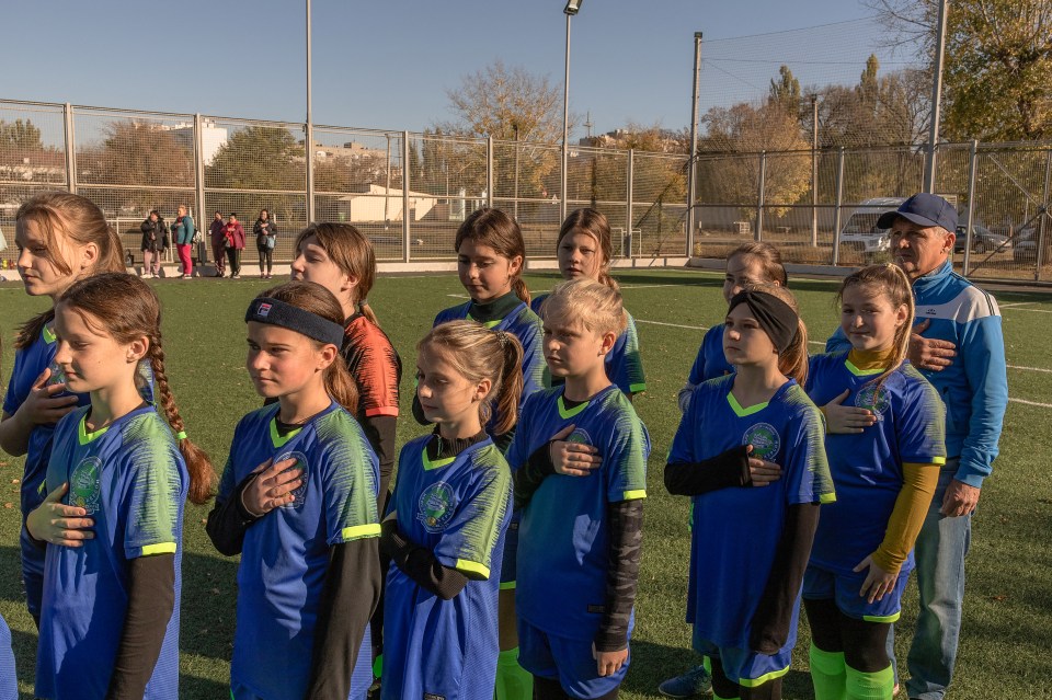 Girls' soccer team from Kherson, Ukraine, singing their national anthem before a tournament.
