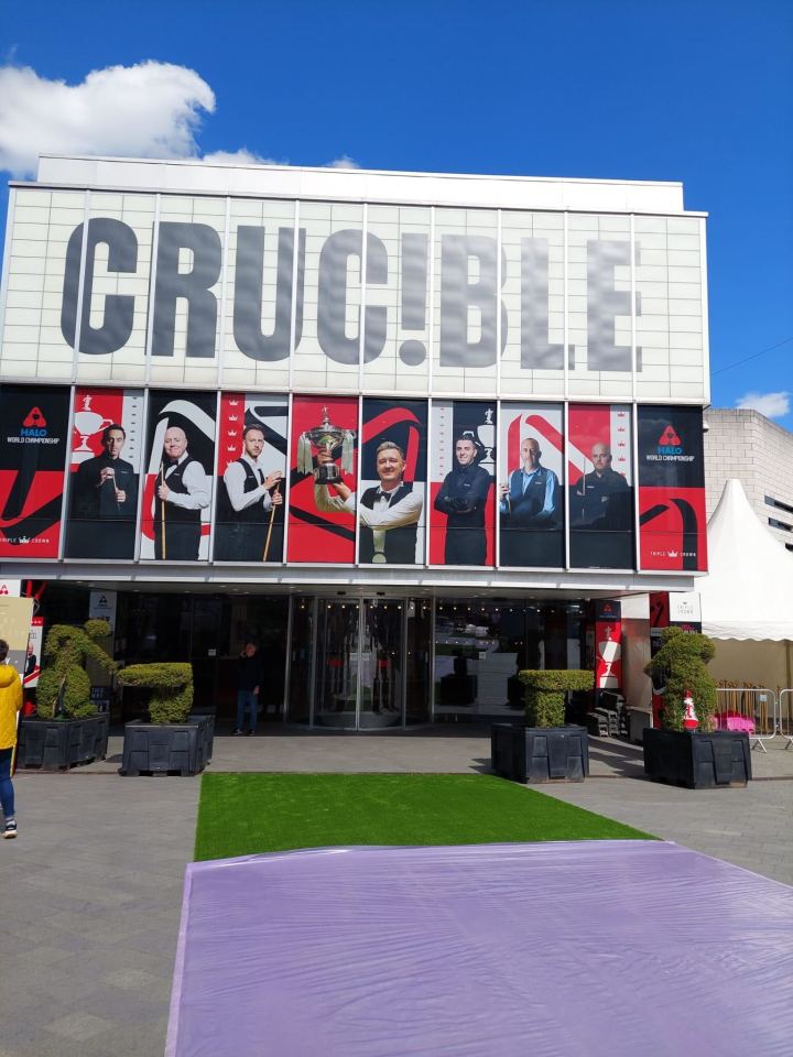 The Crucible Theatre with snooker players displayed on its exterior.