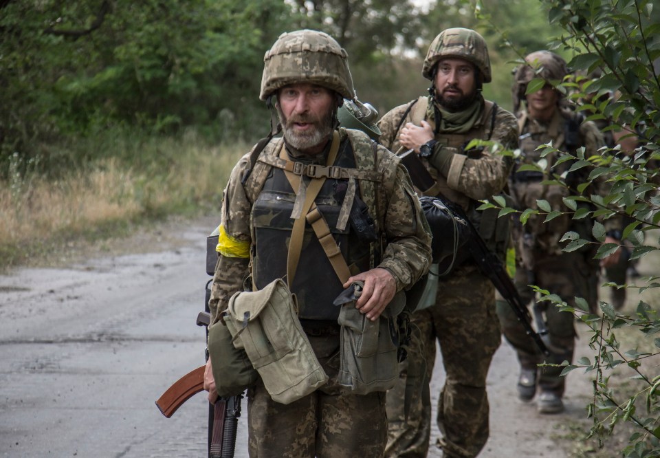 Ukrainian soldiers walking on a road.