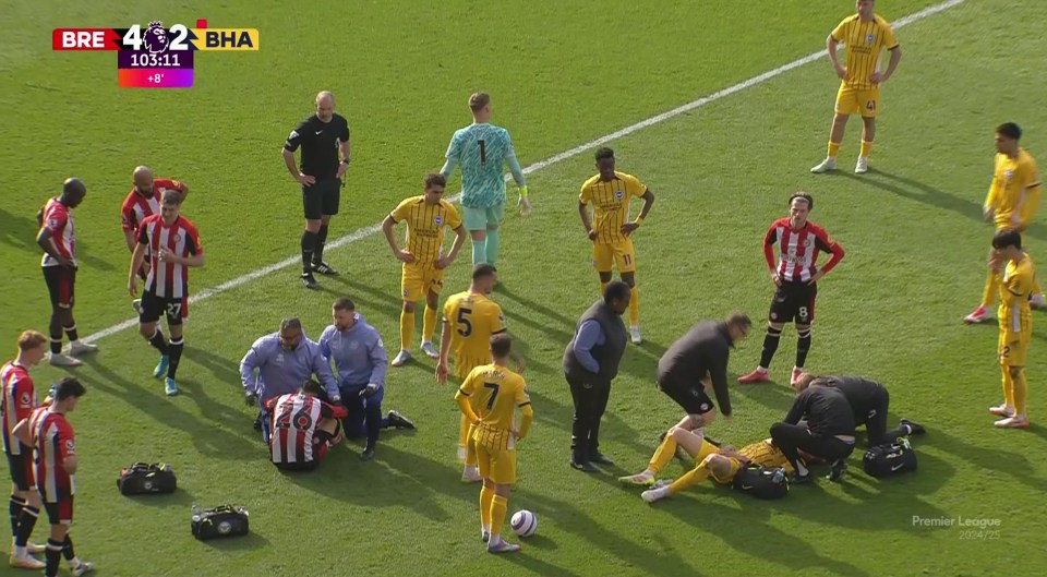 Injured soccer player receiving medical attention on the field.