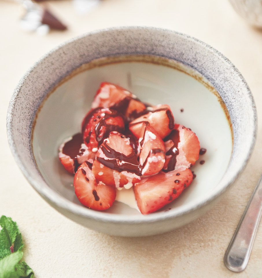 Strawberries with chocolate sauce and cream in a bowl.