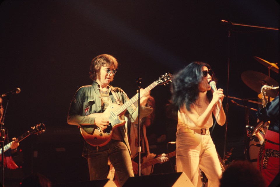 John Lennon and Yoko Ono performing at a concert.