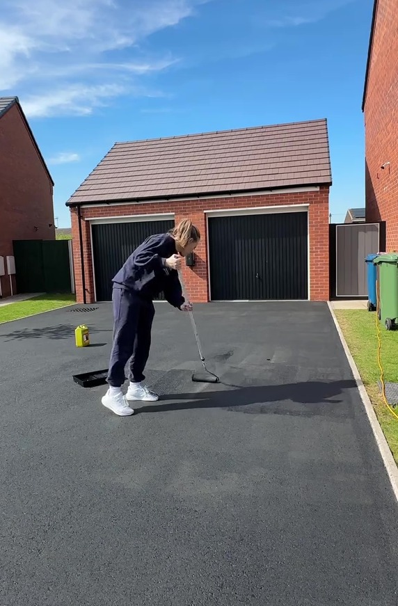 Person applying sealant to a driveway.