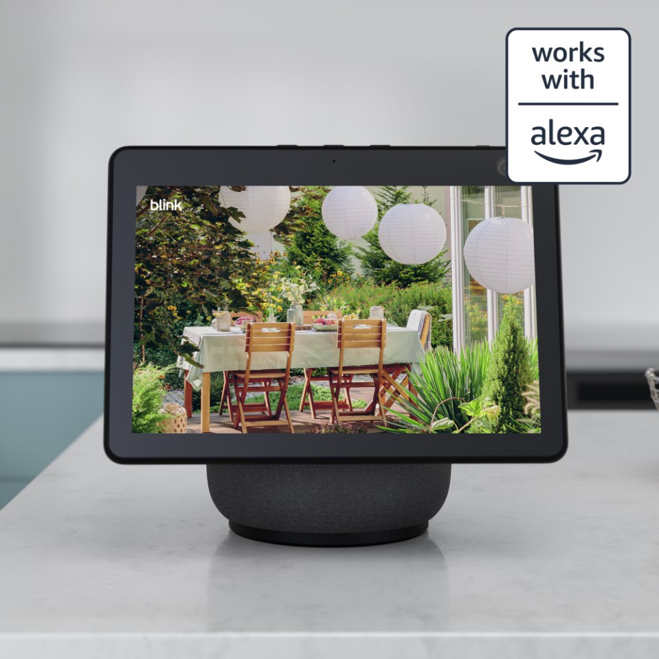 Blink smart display showing an outdoor patio scene with a table and chairs, works with Alexa.