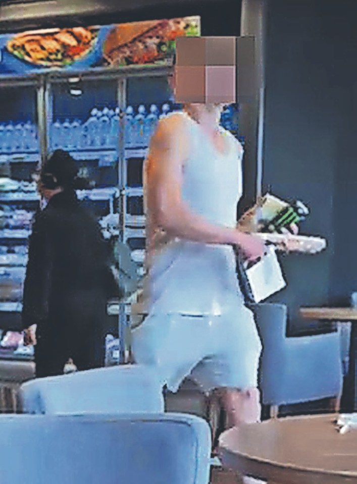 Surveillance image of a man in a white vest carrying food and drink in a Greggs.