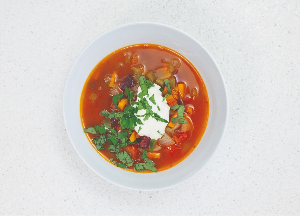 Bean and tomato soup with sour cream and cilantro.