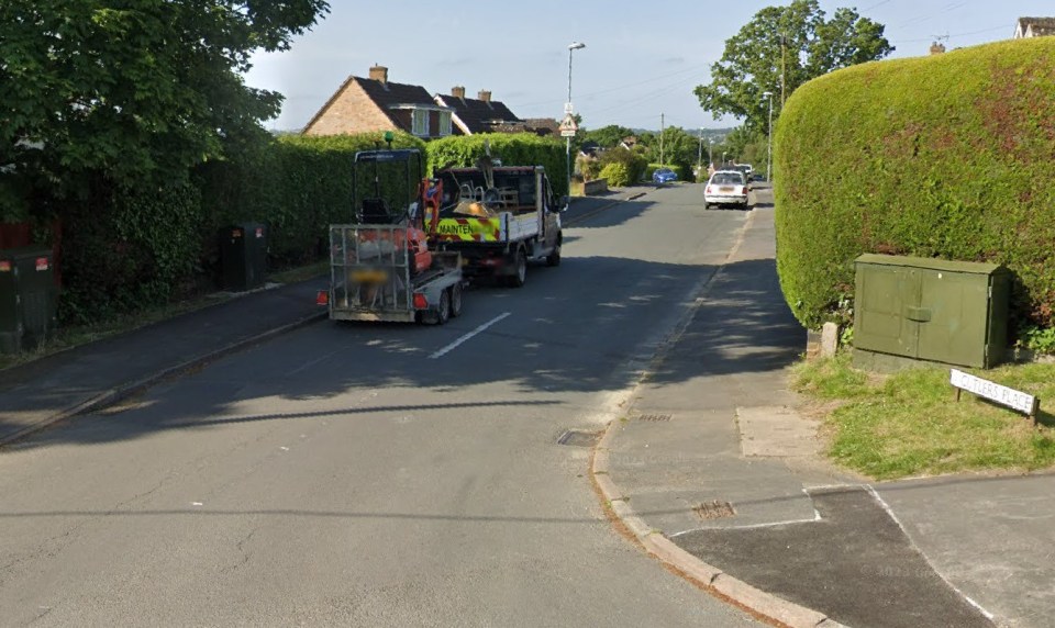 Street scene with a small digger on a trailer being towed by a van.