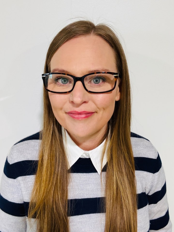 Headshot of a woman wearing glasses and a striped sweater.