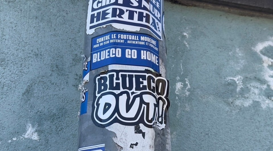 Stickers on a pole reading "Bluéco Go Home" and "Bluéco OUT!" in French and English.
