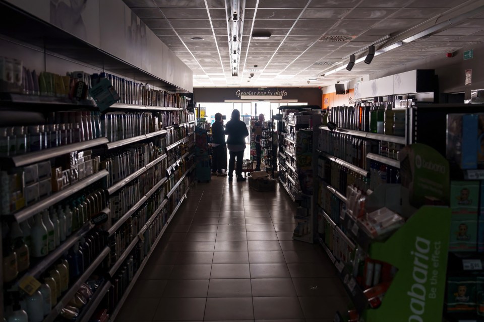 Employees stand inside a supermarket without lights in Burgos on April 28, 2025, during a massive power cut affecting the entire Iberian peninsula and the south of France. A "massive" power cut late on April 28, 2025 morning affected the whole of the Iberian peninsula and part of France, according to Portuguese electricity network operator REN. (Photo by CESAR MANSO / AFP) (Photo by CESAR MANSO/AFP via Getty Images)