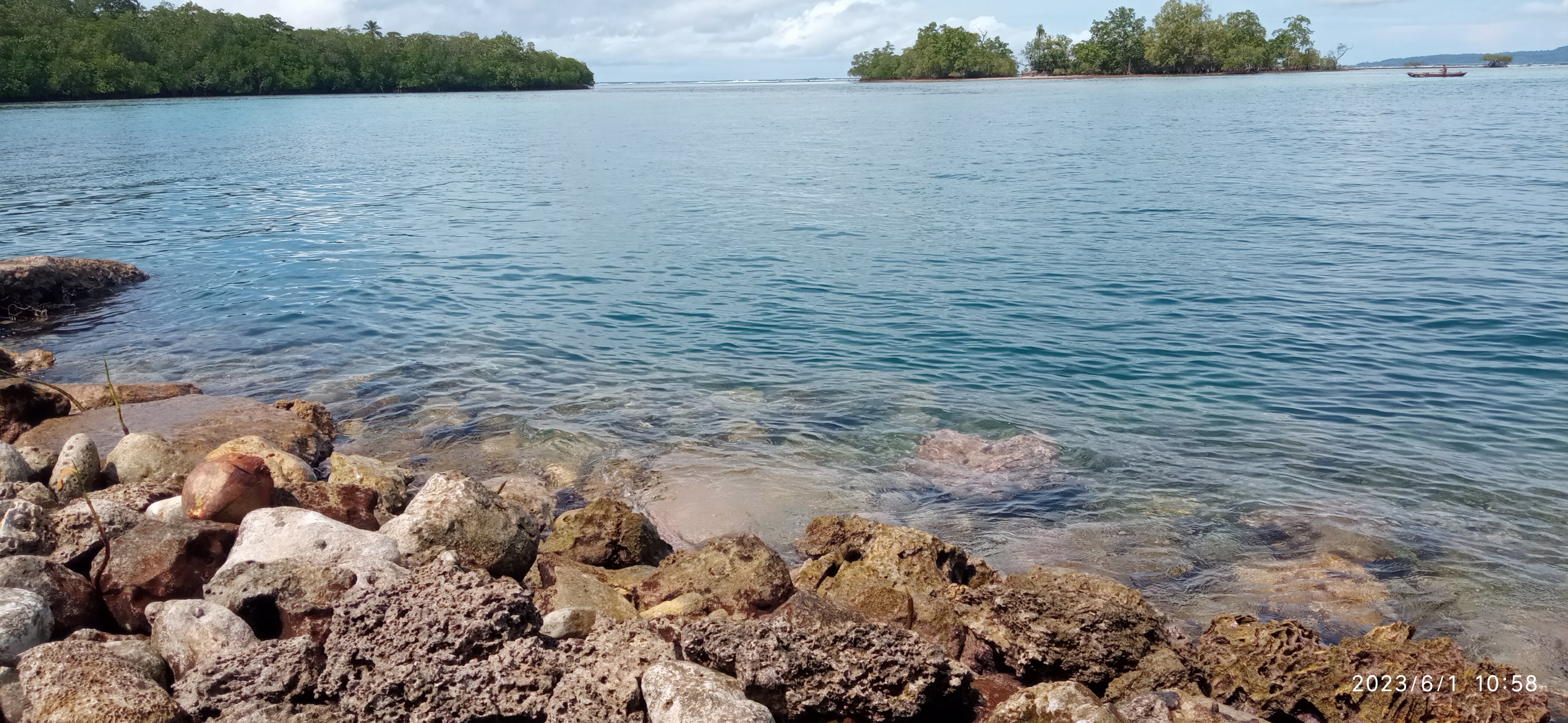 Rocky shoreline and calm blue water.