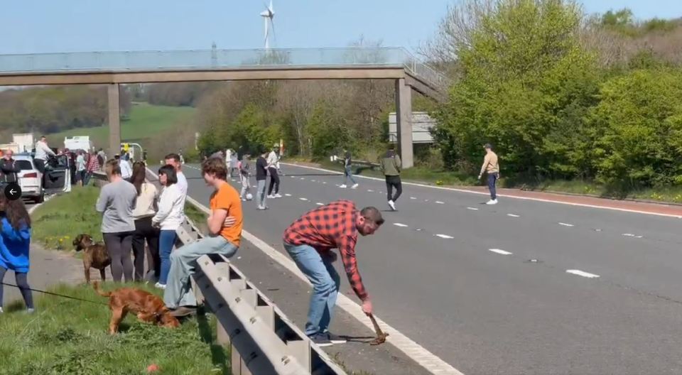 People standing and walking on a motorway after a serious crash.