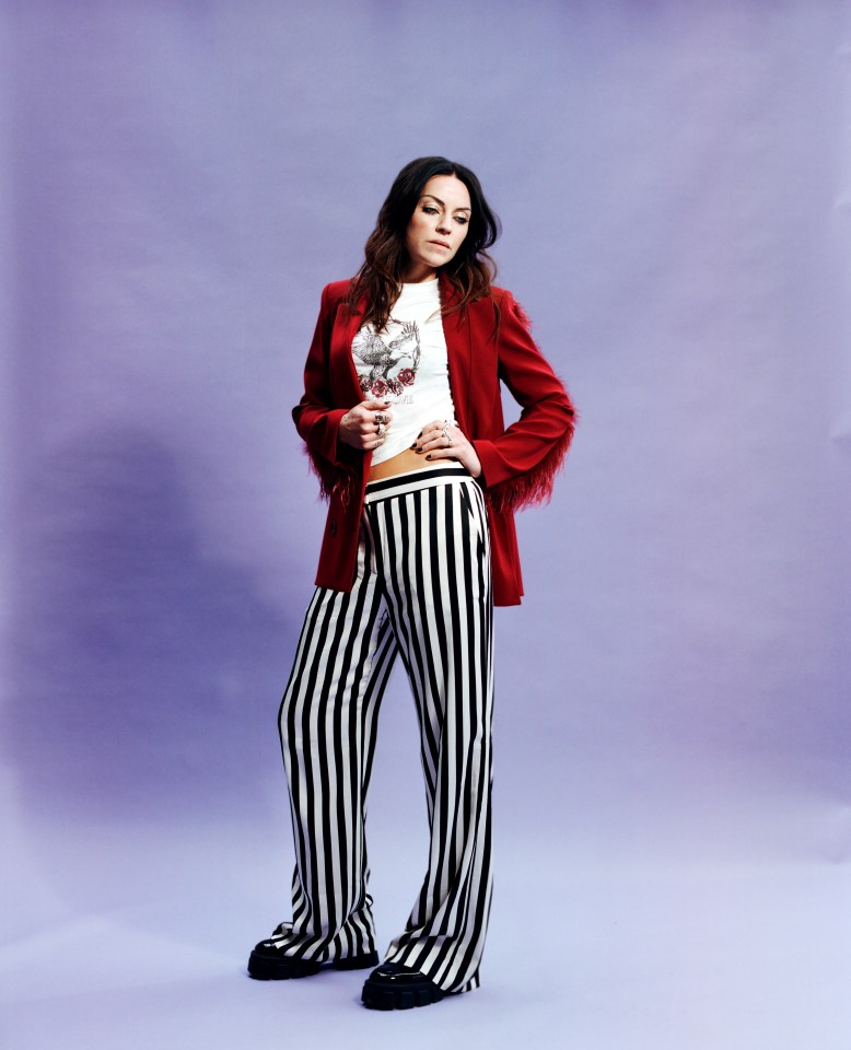 Amy Macdonald in a red blazer and black and white striped pants.